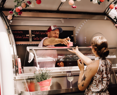 Mathias von Bitte mit Sahne bei der Ausgabe von Eis während eines Caterings anlässlich einer Hochzeit